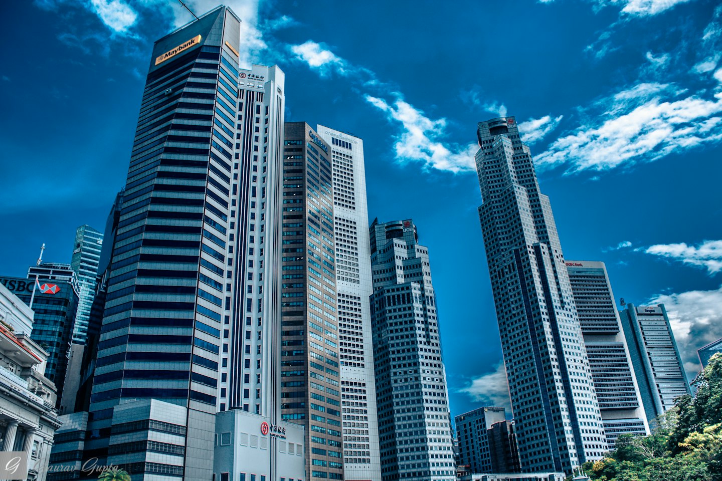 Modern skyscrapers rise toward a blue sky in a city district.